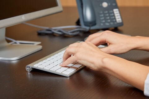 Modern office workspace close up hands typing phone